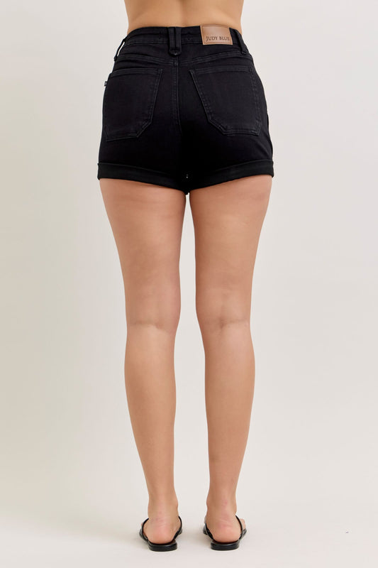 Black denim shorts worn by a person on a white background