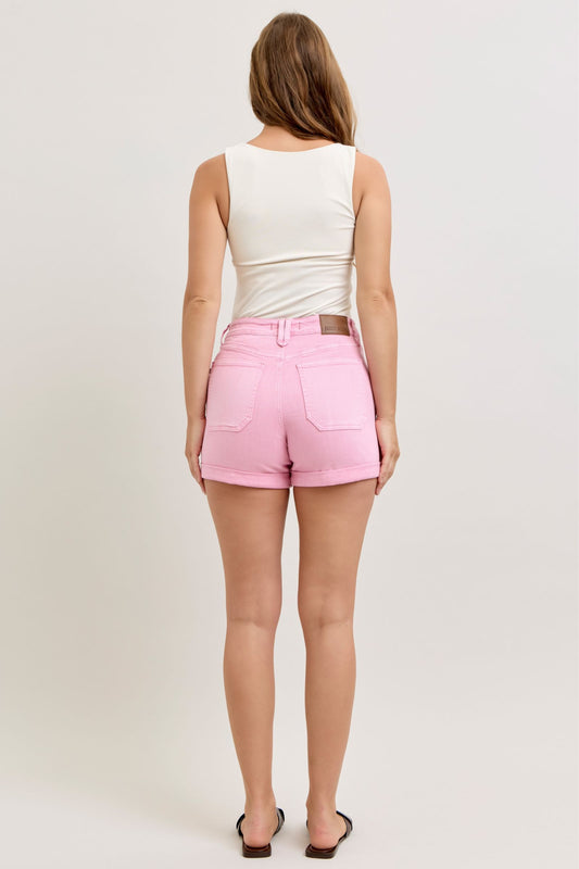 Person wearing pink shorts and a white top on a plain background