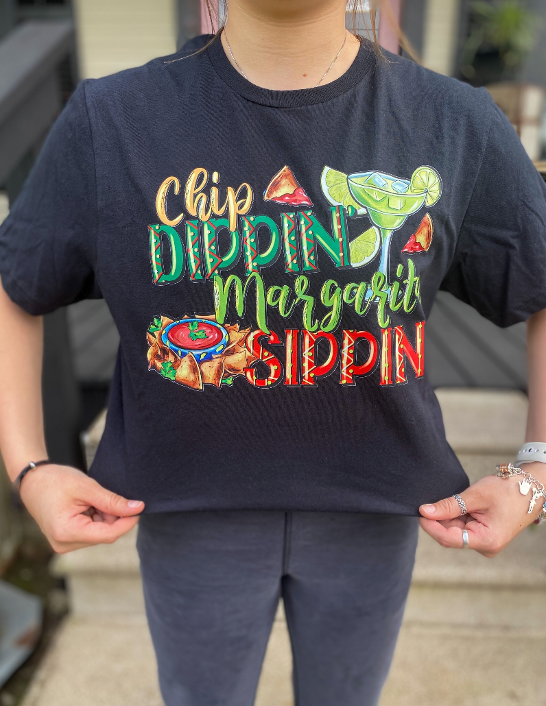 Person wearing a black t-shirt with colorful text and graphics.