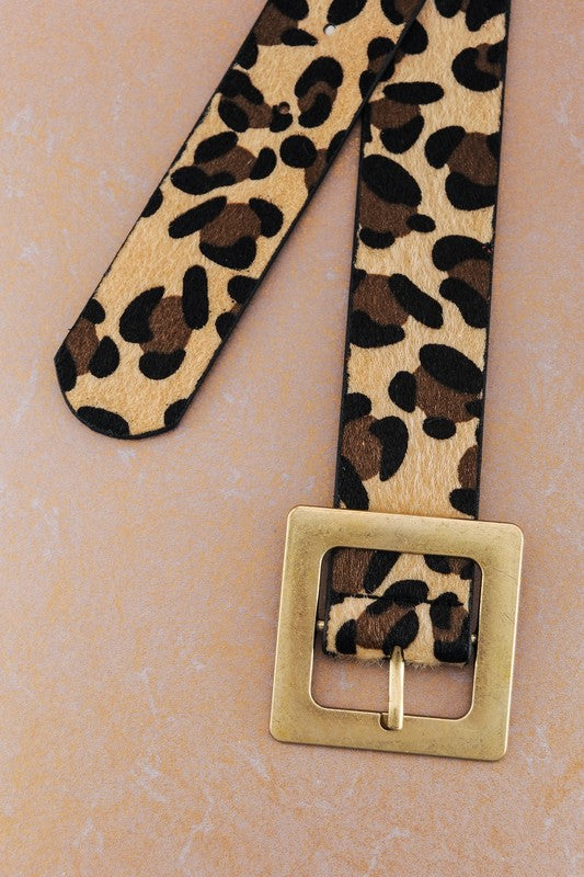 Leopard print belt with a gold buckle on a beige background