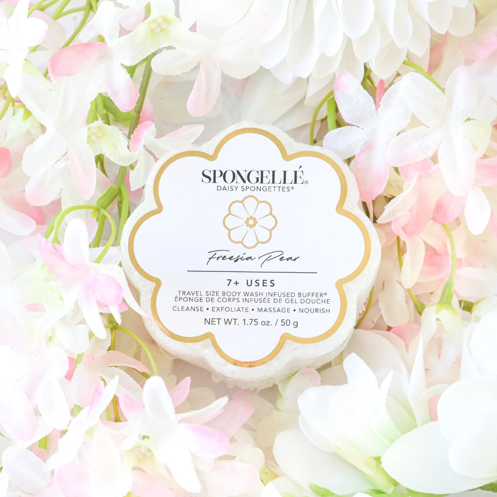 Spongellé product with 'Fresia Pear' scent surrounded by white and pink flowers