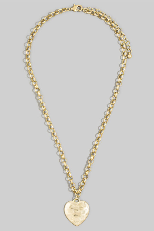 Gold chain necklace with a heart-shaped pendant on a gray background