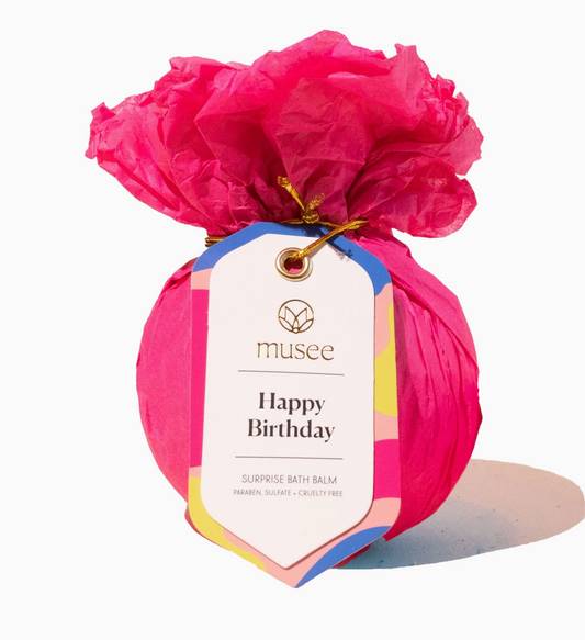 Pink bath balm with a 'musee' tag on a white background