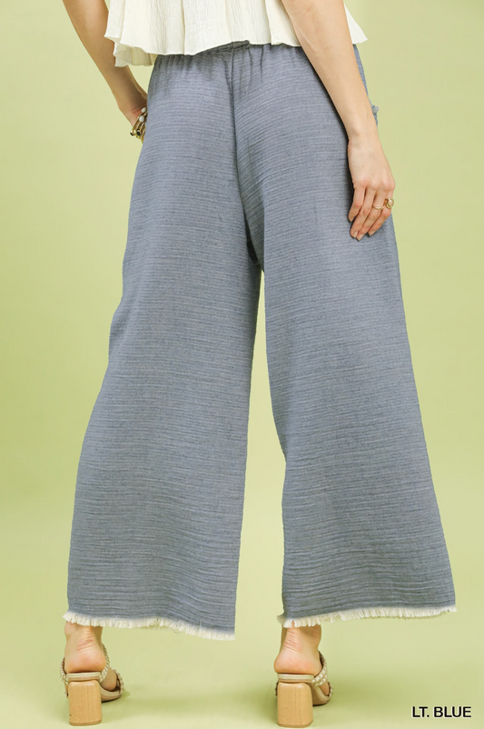 Light blue wide-leg pants worn by a person on a light green background