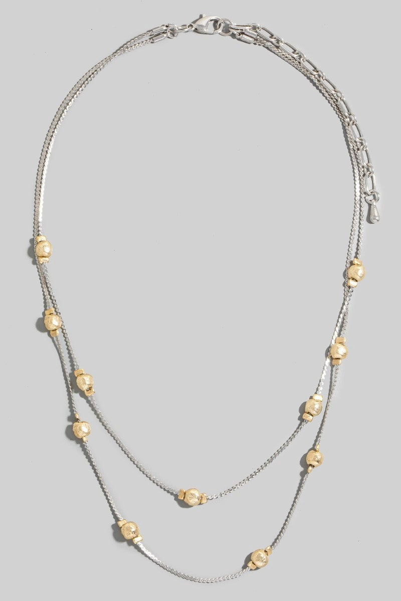 Necklace with gold beads on a gray background