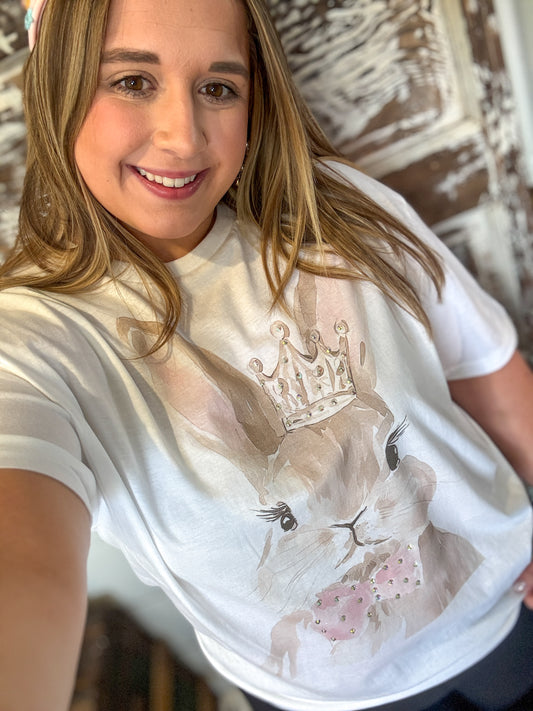 Person wearing a white t-shirt with a graphic design of a cat and crown.