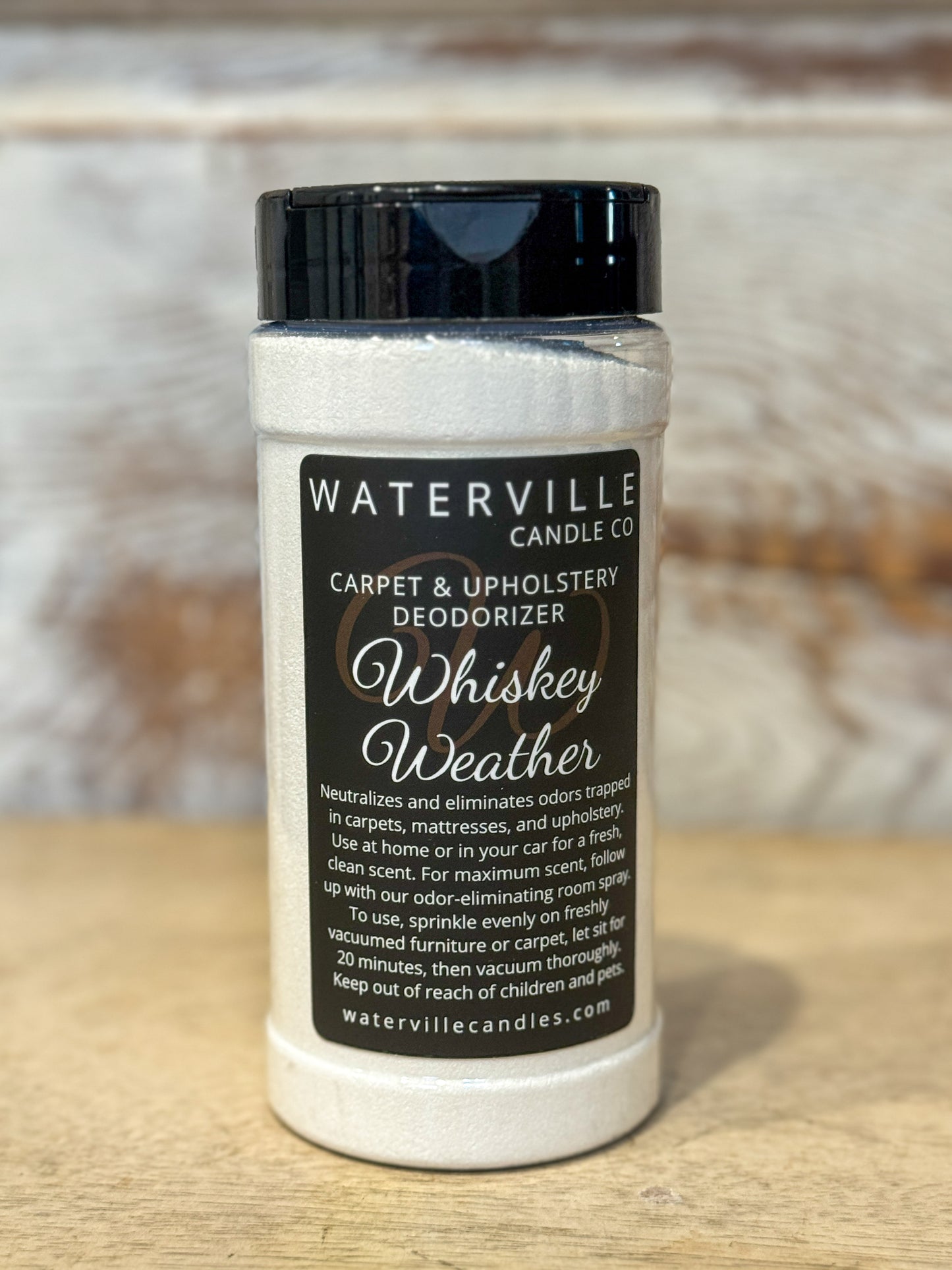 Jar of Waterville Candle Co. carpet and upholstery deodorizer labeled 'Whiskey Weather' on a wooden surface.