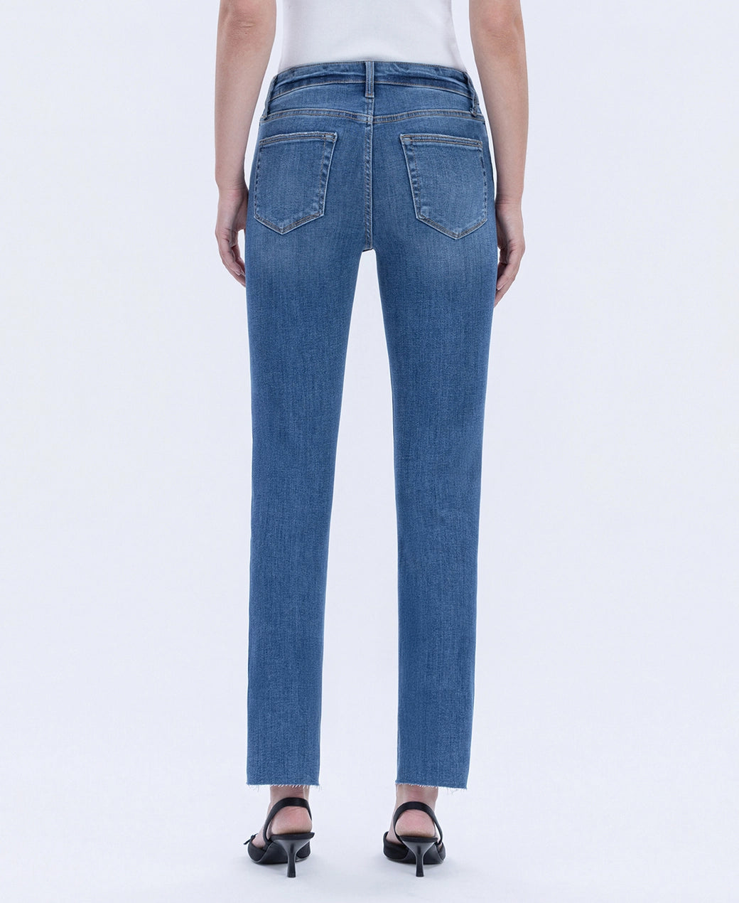 Blue jeans worn by a person on a white background