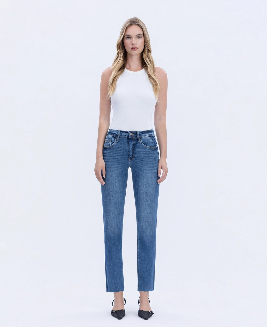 Woman wearing blue jeans and a white top on a white background