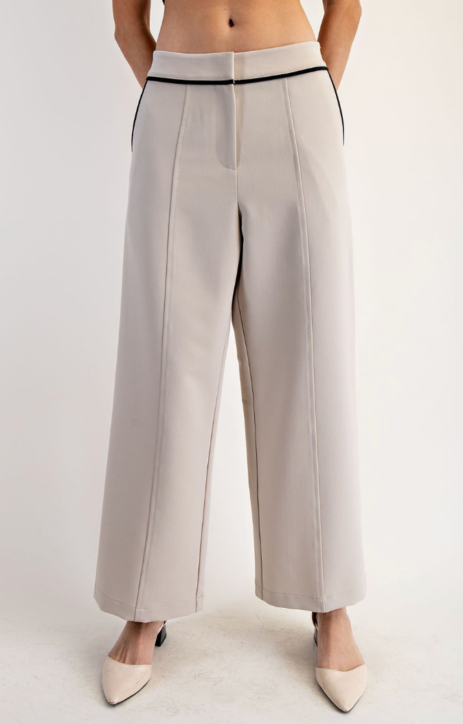 White pants worn by a person on a plain background