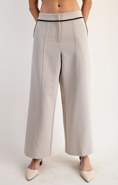 White pants worn by a person on a plain background