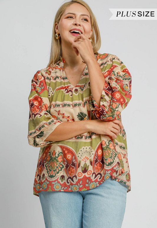 Woman wearing a plus-size patterned blouse with a plain background