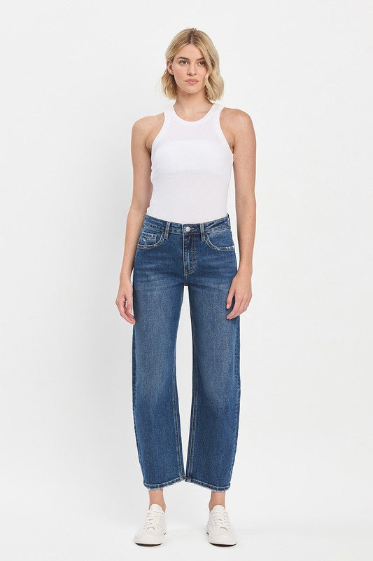 Woman wearing a white tank top and blue jeans on a white background