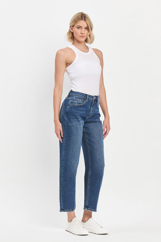 Woman wearing a white sleeveless top and blue jeans on a white background