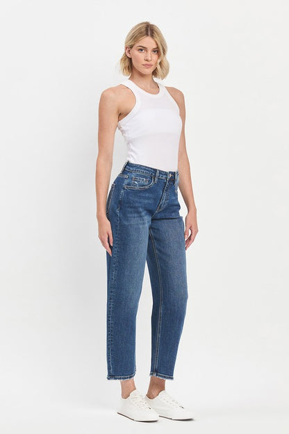 Woman wearing a white sleeveless top and blue jeans on a white background