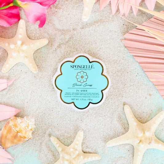 Spongelle product packaging on sand with starfish and flowers