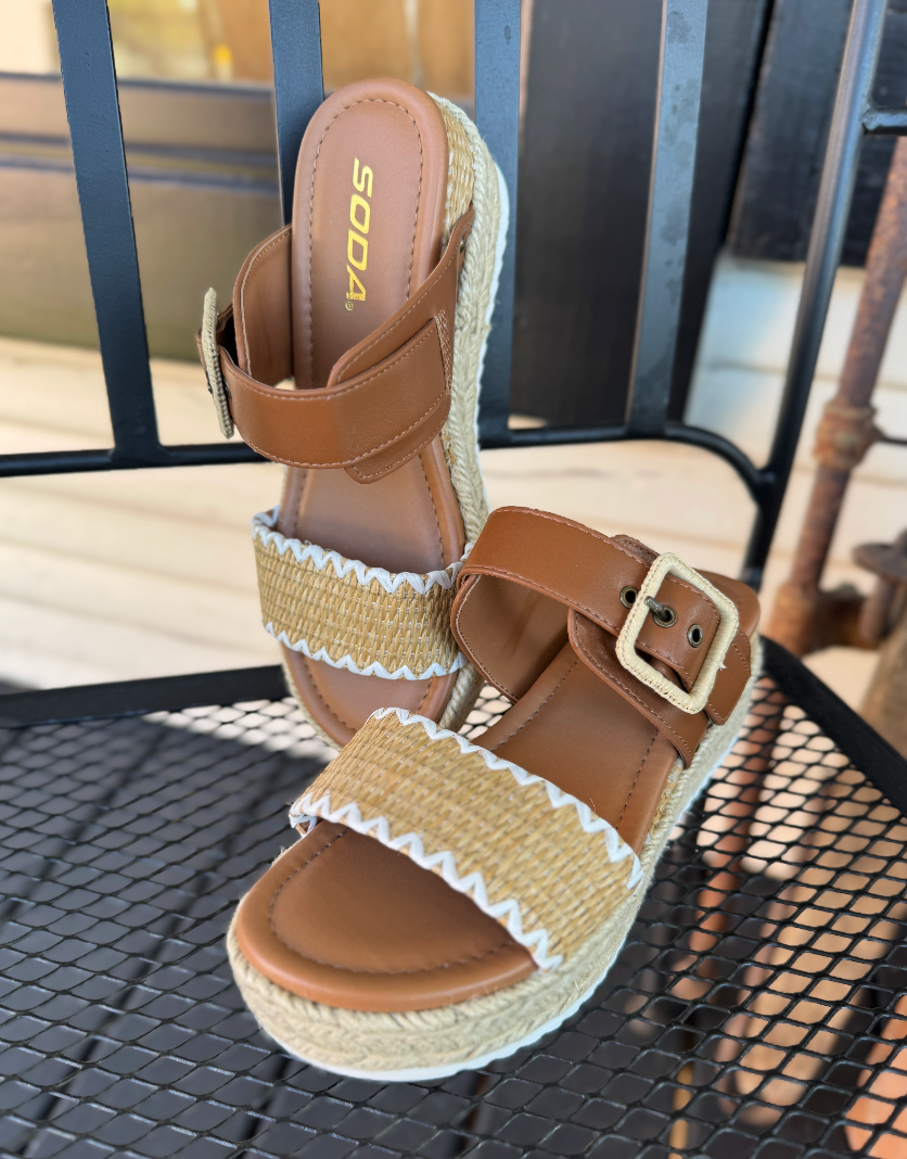 Brown sandal with straw details on a metal chair