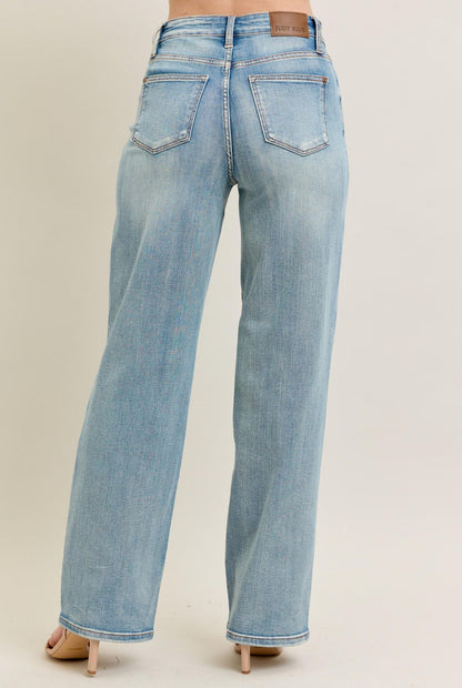 Light blue jeans worn by a person on a beige background
