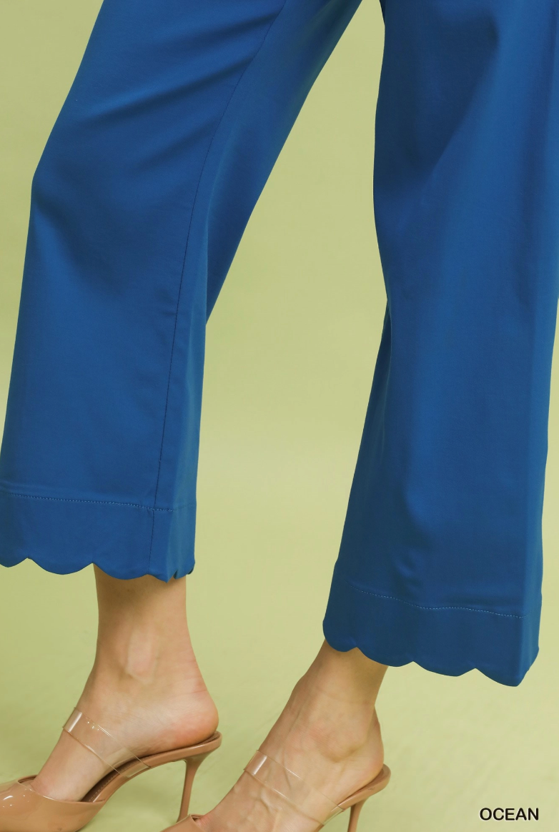 Blue pants with scalloped hem on a light green background