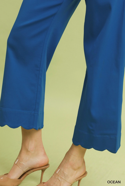Blue pants with scalloped hem on a light green background