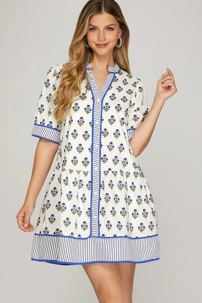 Woman wearing a floral dress with blue accents on a gray background