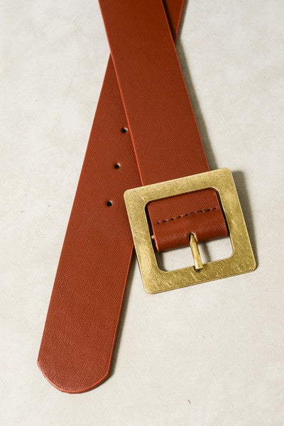 Brown leather belt with a gold buckle on a beige background