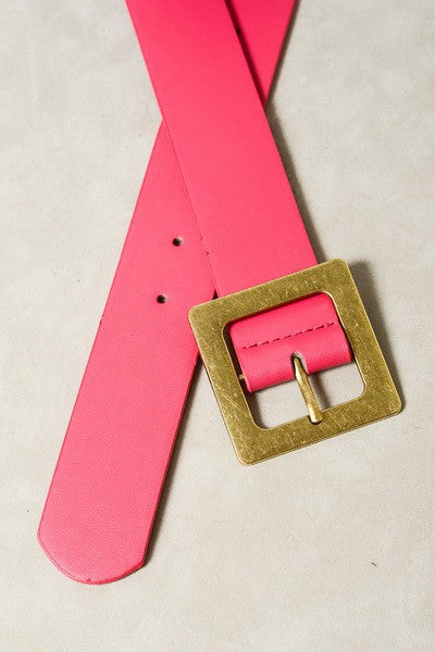 Pink belt with a gold buckle on a beige background