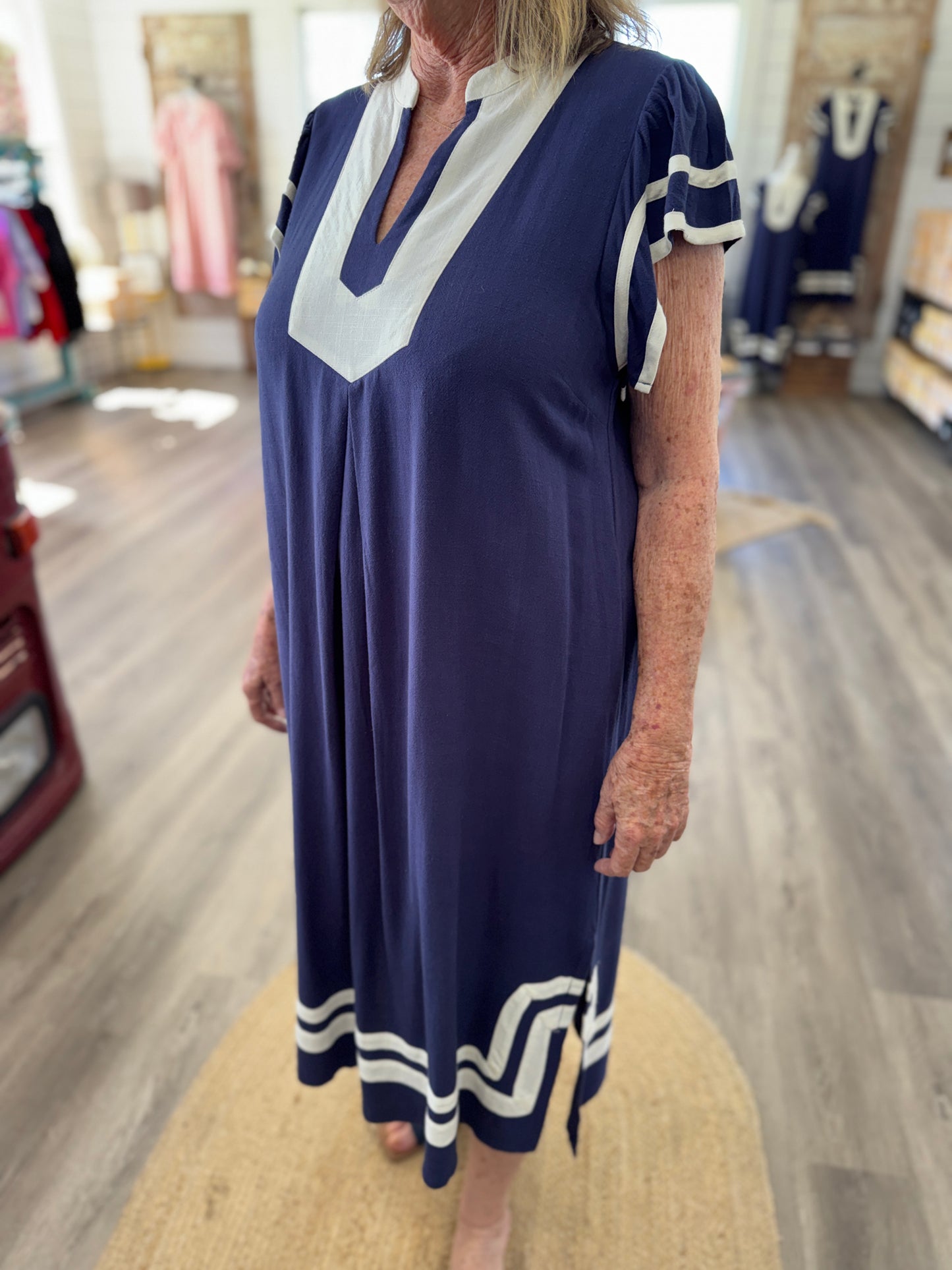 Woman wearing a navy dress with white accents in a store setting