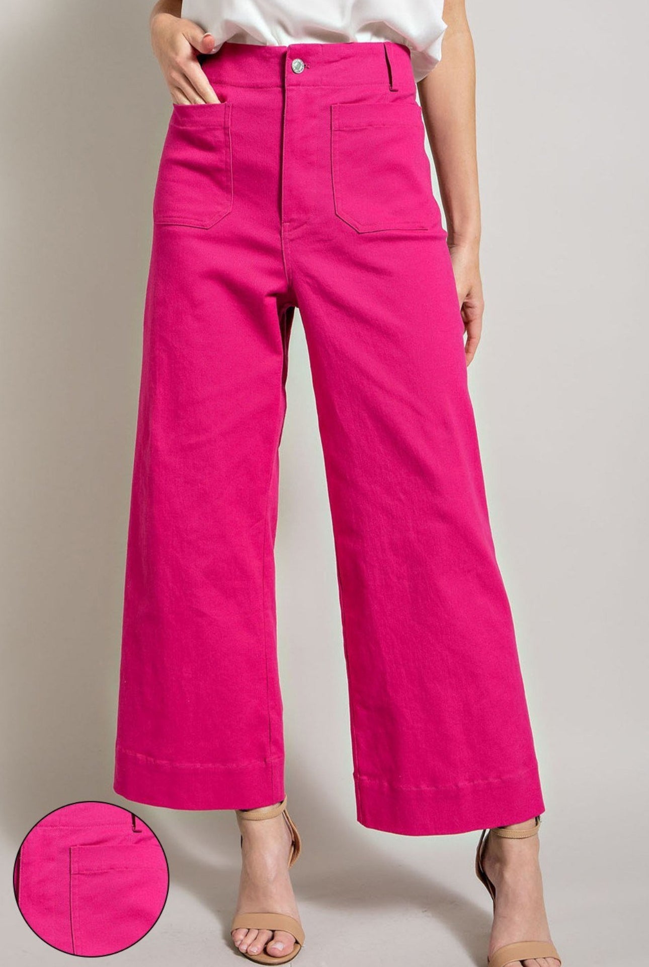 Person wearing bright pink pants on a neutral background