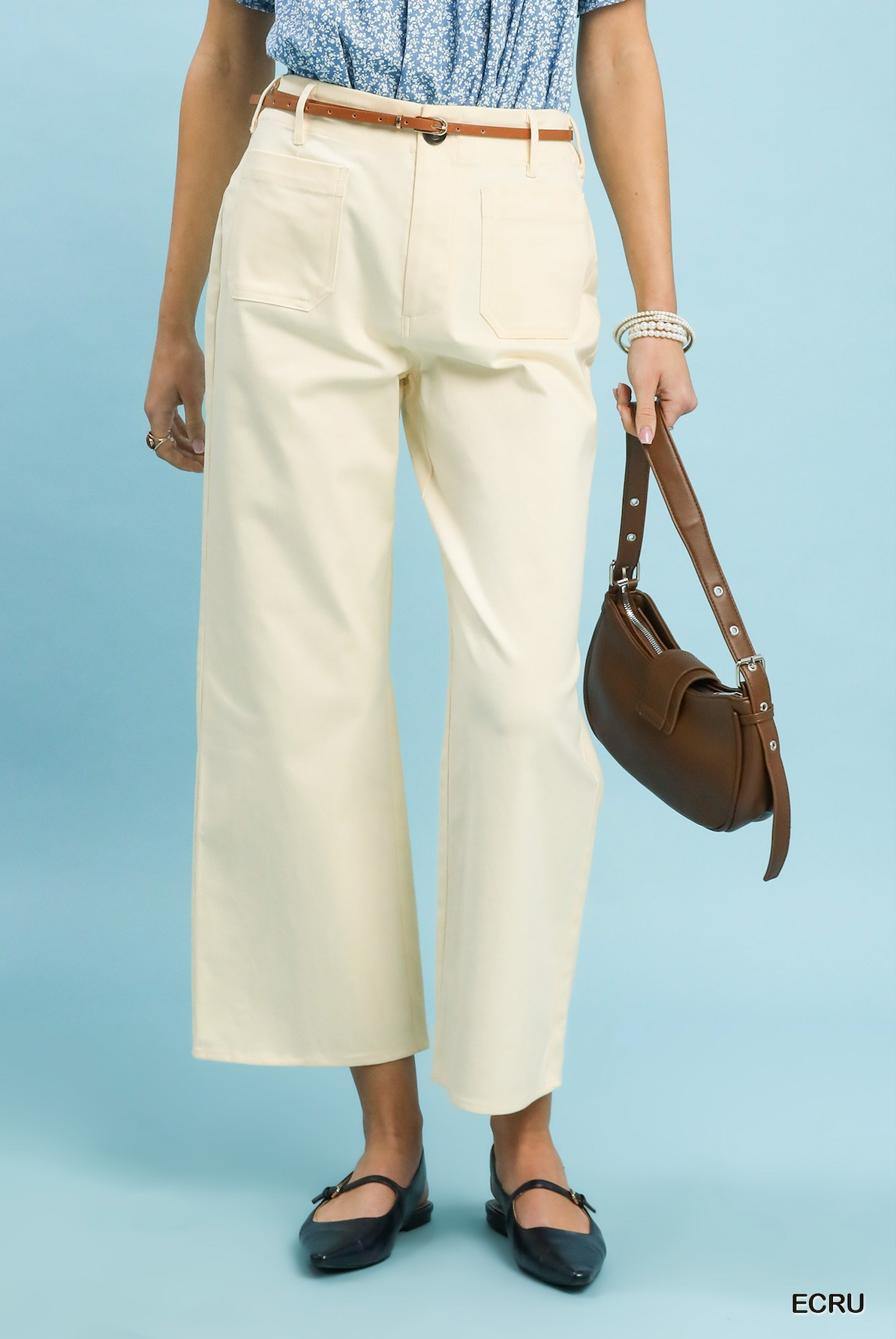 Women wearing ecru colored pants on a light blue background.