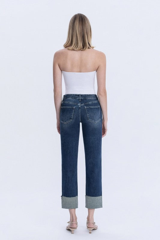 Woman wearing blue jeans and a white top on a white background