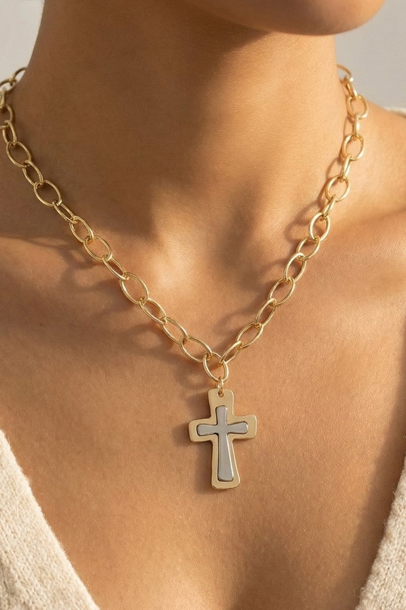 Gold chain necklace with a cross pendant on a person's neck