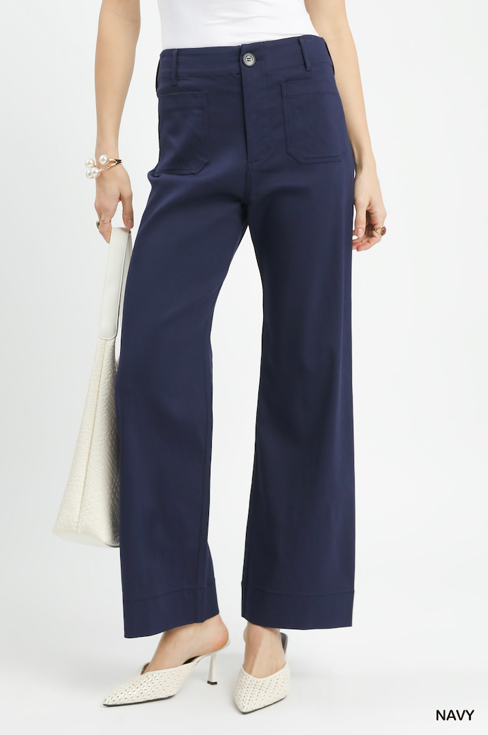 Navy pants worn by a person on a white background