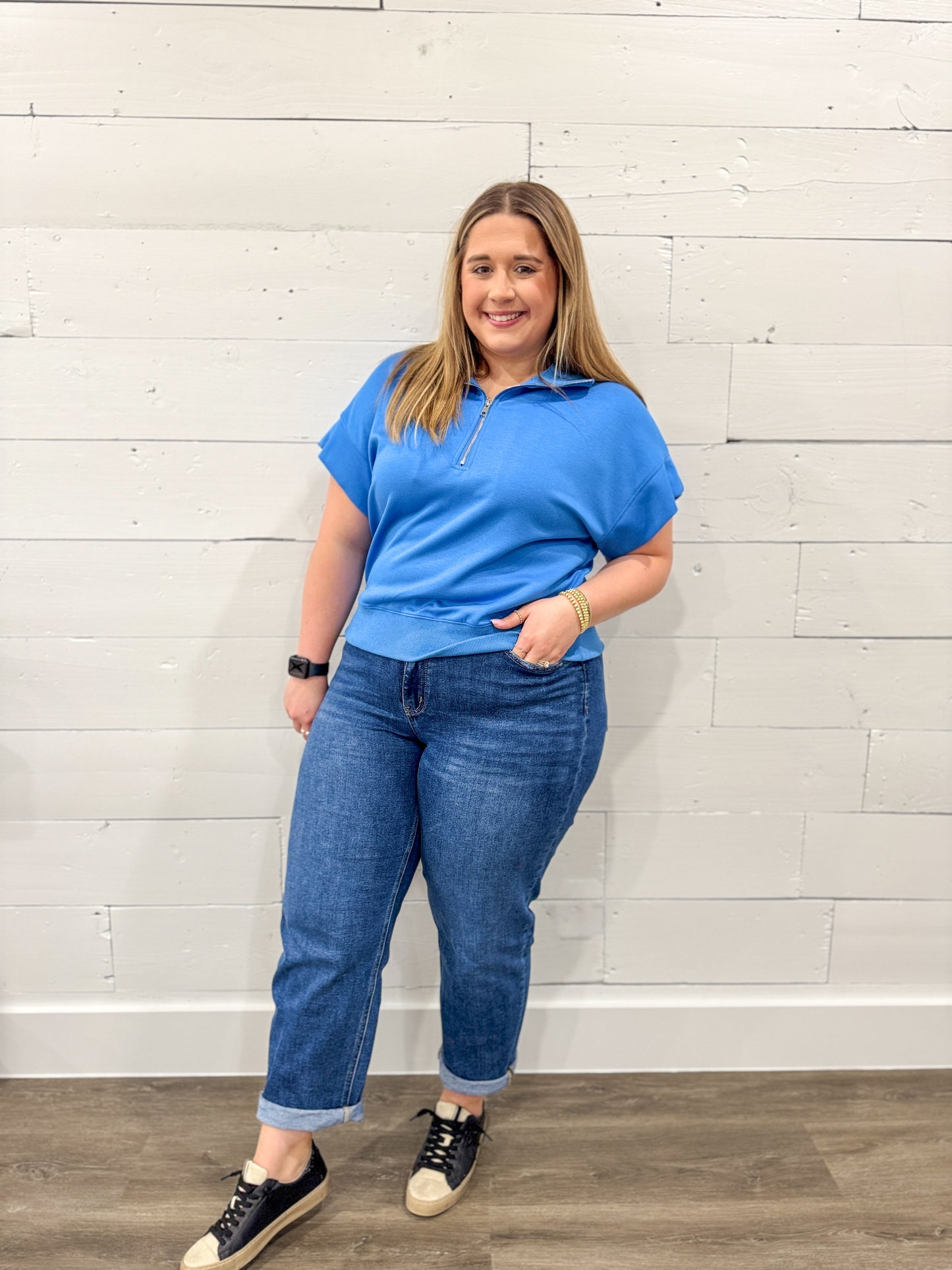 Woman wearing a blue outfit with a white background on a brown floor