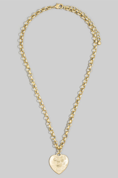 Gold chain necklace with a heart-shaped pendant on a gray background