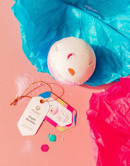 Bath bomb with a colorful tag on a pink and blue background