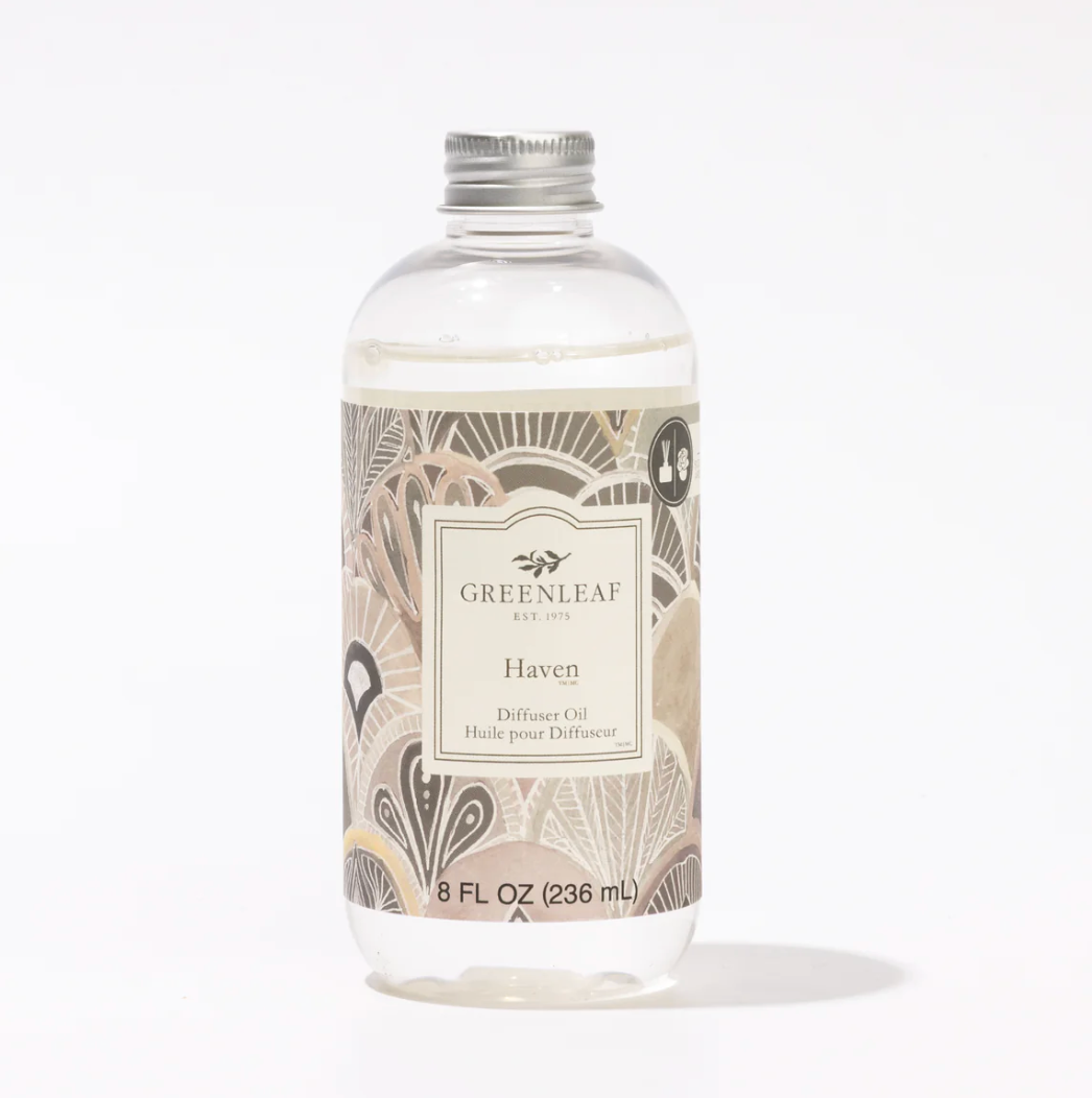 A clear plastic bottle of Greenleaf Est. 2015 Haven Diffuse Oil with a silver metal cap and a beige patterned label, set against a plain white background.