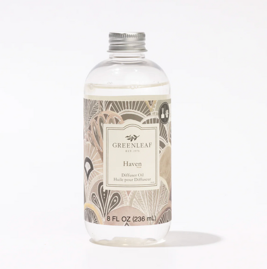 A clear plastic bottle of Greenleaf Est. 2015 Haven Diffuse Oil with a silver metal cap and a beige patterned label, set against a plain white background.