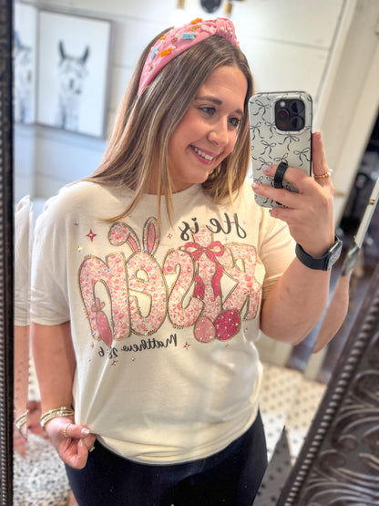Woman taking a mirror selfie wearing a decorative headband and a t-shirt with a graphic design.
