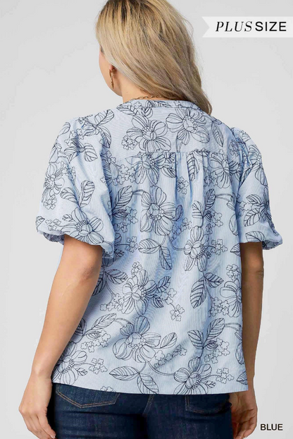 Woman wearing a blue floral blouse with 'Plus Size' text above.