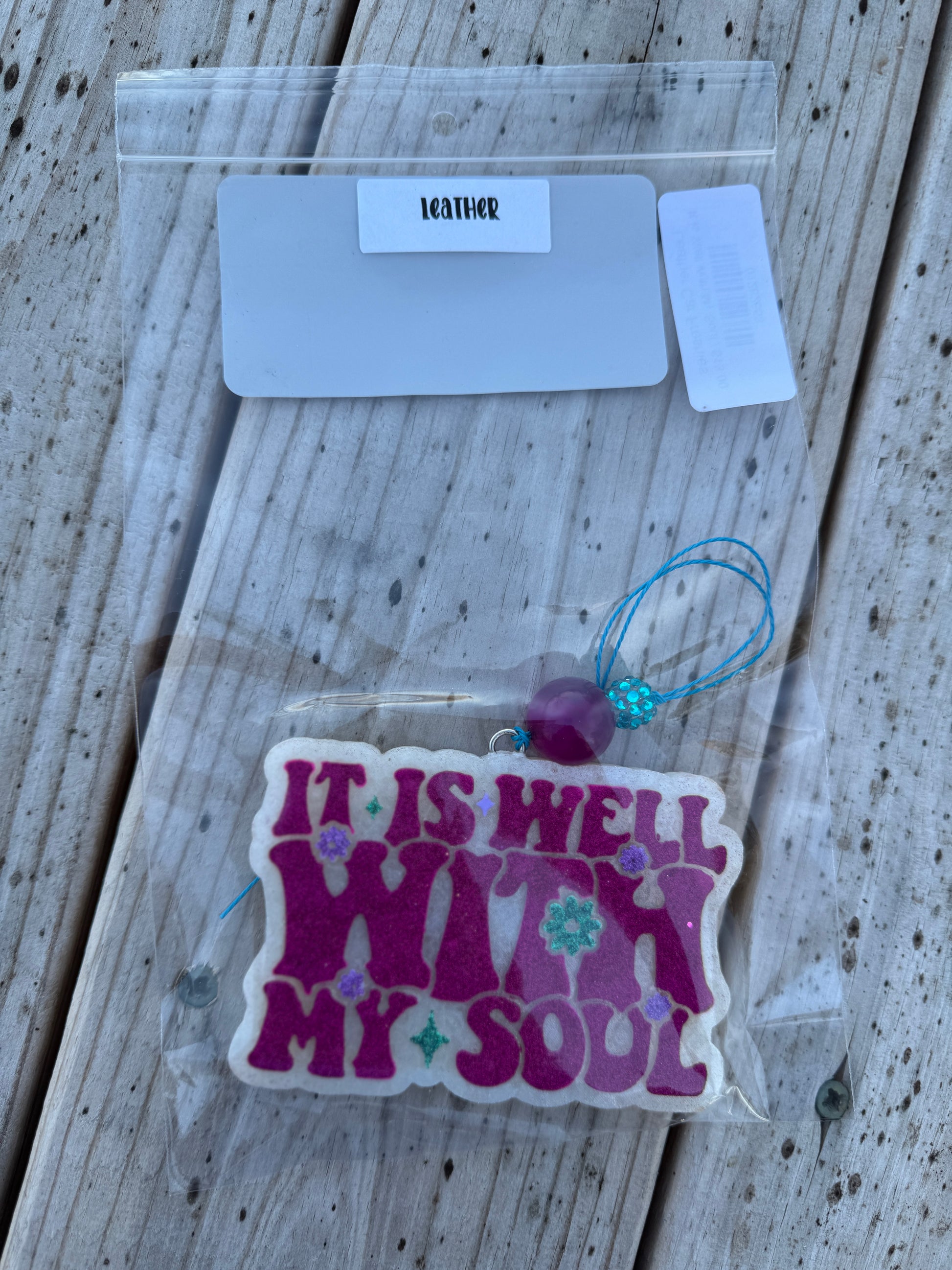 Decorative tag with 'It is well with my soul' text on a wooden surface