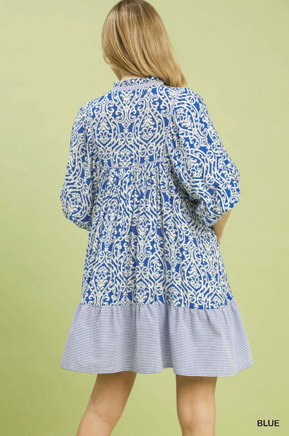 Woman wearing a blue and white patterned dress on a green background