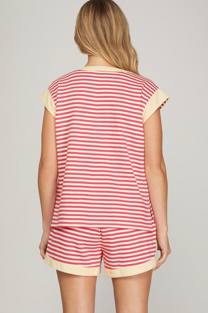 Person wearing a red and white striped romper with yellow trim on a gray background