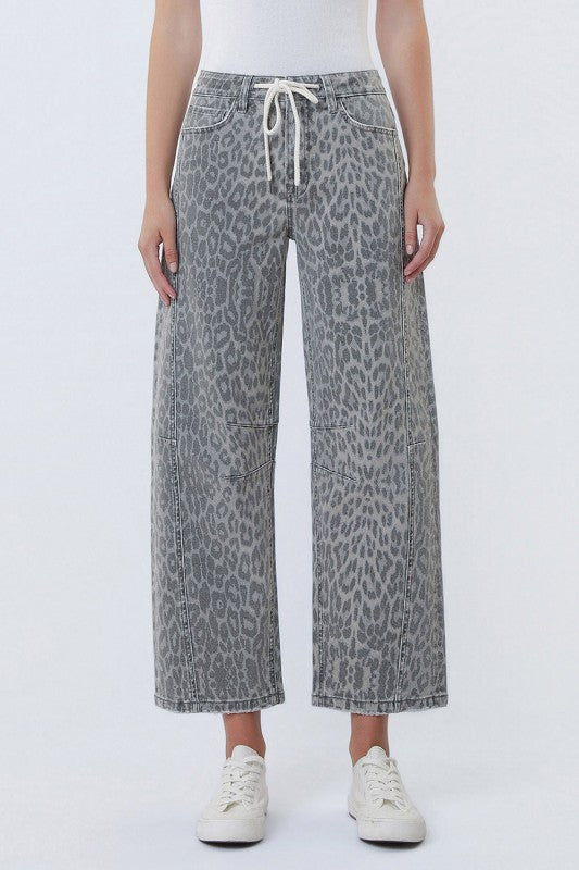 Person wearing gray leopard print pants on a white background