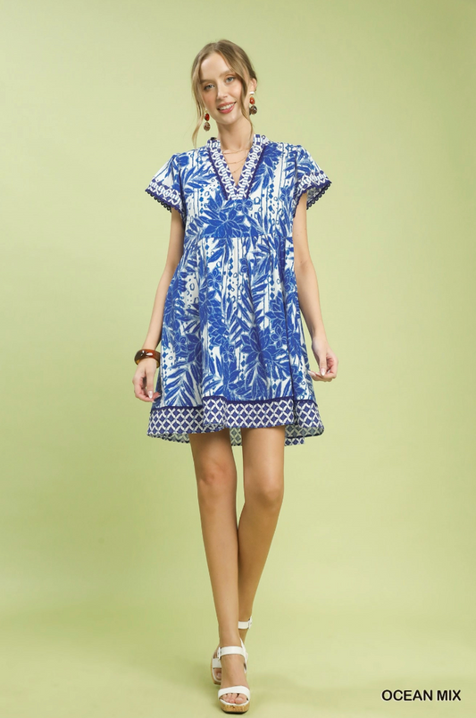 Woman wearing a blue and white patterned dress on a light green background