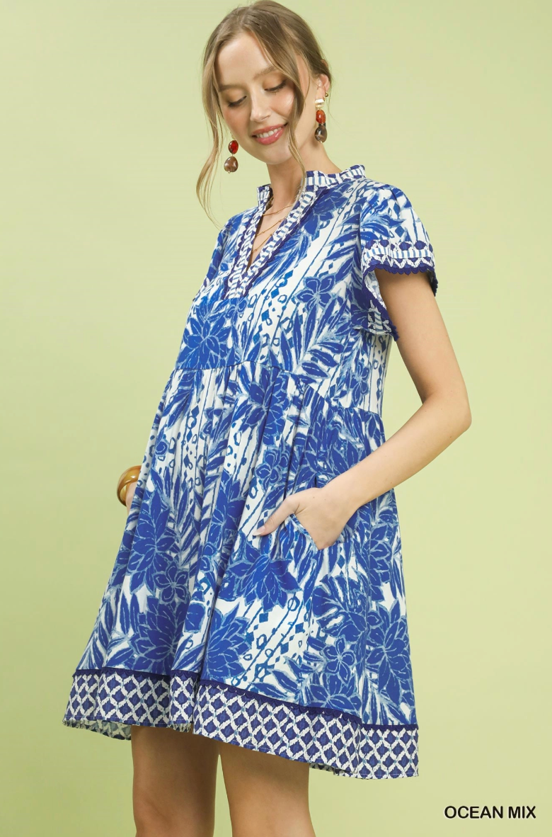 Woman wearing a blue and white patterned dress on a light green background