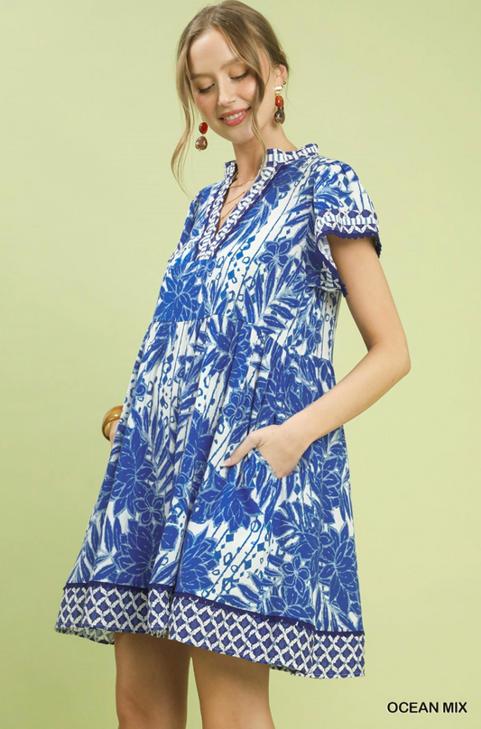 Woman wearing a blue and white patterned dress on a light green background