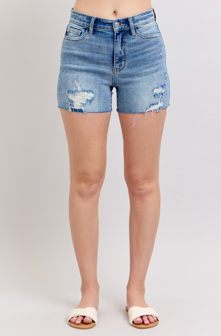 Denim shorts with slight distressing on a plain background