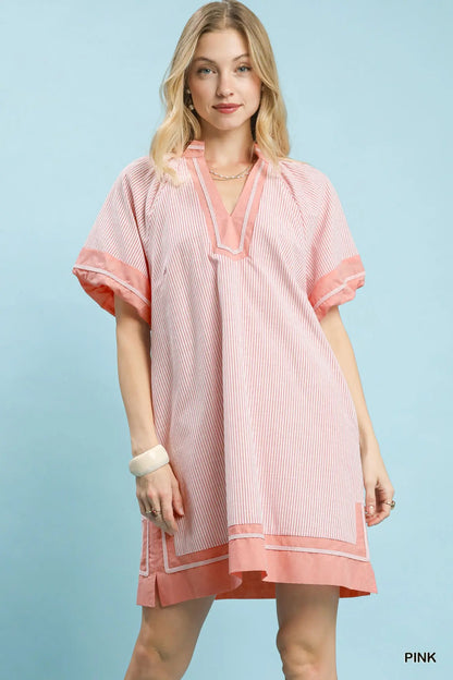 Woman wearing a pink dress with a light blue background