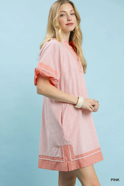 Woman wearing a pink and white patterned dress against a light blue background